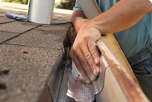 Person repairing or sealing a damaged section along a rooftop edge